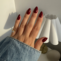 Hand with Instant Mani Co. Rogue Press on Nails wearing a gold ring, against a neutral background