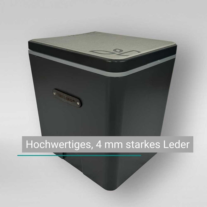 Eine schwarze Schachtel mit robusten Ledergriffen und silbernem Deckel, Etikett: 4 mm starkes Leder.